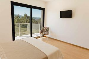 - une chambre avec un lit et un balcon avec une télévision dans l'établissement Casa dos Mirtilos Legacy T7, à Castelbuono