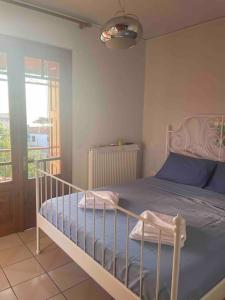 a bedroom with a bed with blue sheets and a window at Melianto House in Mythimna