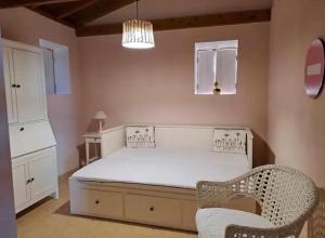 1 dormitorio con 1 cama blanca y 1 silla en O Abrigo, en Laje