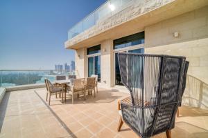 een patio met een tafel en stoelen op een balkon bij Mangrove Place, Reem Island, Abu Dhabi - Mint Stay in Abu Dhabi