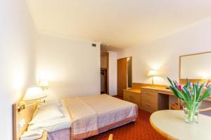 a hotel room with a bed and a table at Hotel Solny in Kołobrzeg