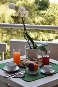 - une table avec des aliments pour le petit-déjeuner et un vase avec des fleurs dans l'établissement Hotel Imperiale & Spa, à Fiuggi