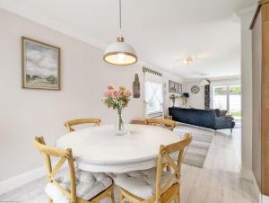a dining room and living room with a white table and chairs at Sweetpea Cottage in Hambrook