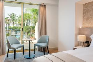 a hotel room with a bed and two chairs and a table at Sir Anthony in Playa de las Americas