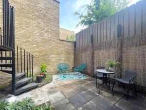 a patio with two chairs and a table next to a brick wall at Sweet&Stylish 1 bed flat in CamdenTown in London