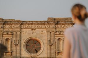 Relais Monastero Santa Teresa - Albergo Diffuso في ناردو: رجل يقف أمام مبنى به نافذة