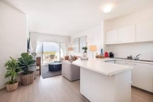 a kitchen with white cabinets and a white counter top at Santorini Perissa Seaview Apartment in Shakaskraal