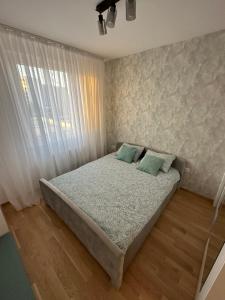 a bedroom with a bed and a window at Apartman EMA in Banja Luka