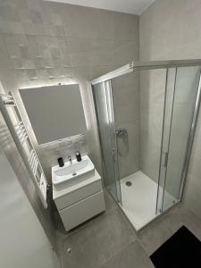 a bathroom with a shower and a sink and a glass shower stall at Apartman EMA in Banja Luka