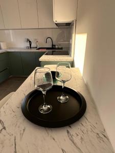 two wine glasses on a black tray on a kitchen counter at Apartman EMA in Banja Luka