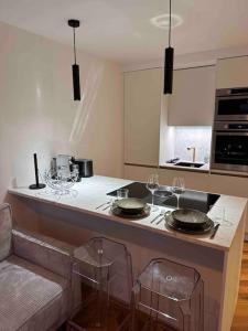 - une cuisine avec un comptoir avec des verres à vin dans l'établissement Appartement rénové entre terre et mer avec piscine, à Calenzana