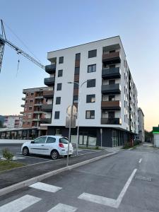 a white car parked in front of a building at Apartman EMA in Banja Luka +40 photos