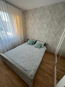 a bedroom with a bed with two green pillows at Apartman EMA in Banja Luka