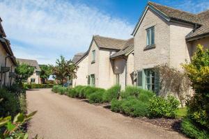 a house with a driveway in a residential neighborhood at Mill Village 59, Millstream Cottage - P in Somerford Keynes