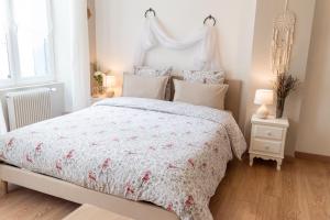 una camera da letto con un letto con copriletto bianco di La Fée Maison a Châtel-sur-Moselle
