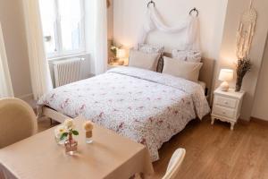 - une chambre blanche avec un lit et une table dans l'établissement La Fée Maison, à Châtel-sur-Moselle