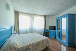 a bedroom with a blue bed and a television at L'incanto Di Boccadarno in Marina di Pisa