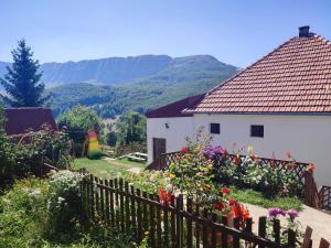 Gacko的住宿－Čemerno Cottage，白色的房子,带有木栅栏和鲜花