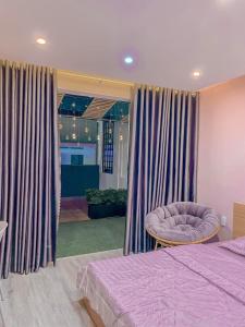 um quarto com uma cama, uma cadeira e cortinas em Amy Hotel em Can Tho