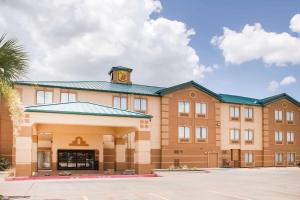 a large brick building with a clock tower on top at Super 8 by Wyndham Port Arthur/Nederland Area in Port Arthur