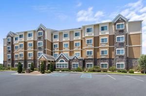 a large apartment building with a parking lot at Microtel Inn and Suites by Wyndham in Opelika