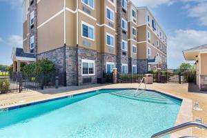 a swimming pool in front of a apartment building at Microtel Inn and Suites by Wyndham in Opelika