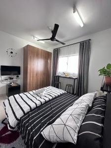 ein großes Bett in einem Schlafzimmer mit Deckenventilator in der Unterkunft Studio D' Alanis in Sepang