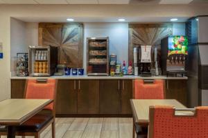 a restaurant with a counter and tables and chairs at Days Inn & Suites by Wyndham Denver International Airport in Denver