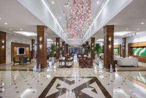a lobby of a hotel with a chandelier at Ramada Resort By Wyndham Lara in Lara