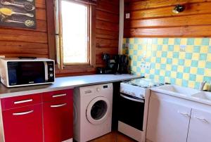 a kitchen with a washing machine and a sink at Le Chalet de la Dordogne in Mauzac-et-Grand-Castang