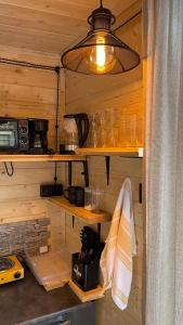 a kitchen with wooden walls and shelves and a light at Pirdapira in Jut'a