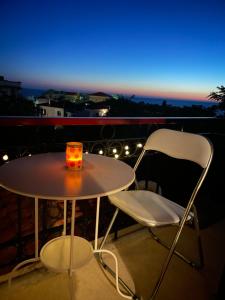 a table and chairs on a balcony at night at Melianto House in Mythimna