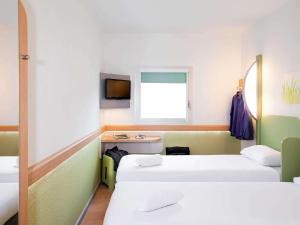 a room with two beds and a tv at ibis budget Beaconsfield in Beaconsfield