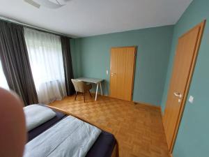 a bedroom with a bed and a desk and a table at Ruhe genießen und wohlfühlen auf 70m² in Ober-Laudenbach