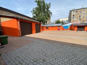 um parque de estacionamento vazio ao lado de um edifício laranja em Apartamenti em Riga