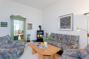 a living room with two couches and a table and a wood stove at Dünenstraße 25 in Zinnowitz