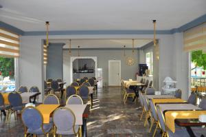 a dining room with tables and chairs and windows at SİDE SPRİNG HOTEL in Side