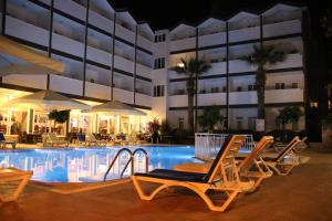 a hotel swimming pool with chairs and a building at SİDE SPRİNG HOTEL in Side