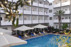 a hotel with a swimming pool with chairs and umbrellas at SİDE SPRİNG HOTEL in Side