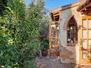 a building with a door in a garden with trees at Beautiful Alamedas: casa rural con piscina in Castronuño