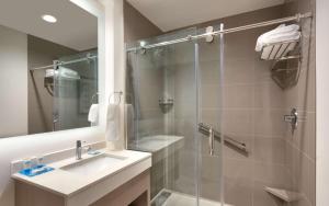 a bathroom with a shower and a sink and a mirror at Hyatt House Provo/Pleasant Grove in Pleasant Grove