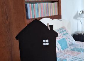 a black house shaped object sitting on a bed at Guesthouse Mare Bar in Bar