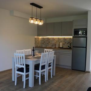 a kitchen with a white table and white chairs at Blu Bay in Grzybowo