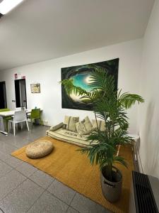 a living room with a couch and a plant on the floor at My Room Zen Relax in Reggio Emilia