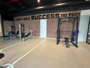 a gym with several tread machines and a brick wall at Sentral Suites KualaLumpur in Kuala Lumpur