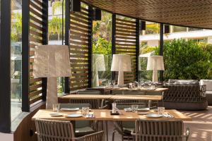 a restaurant with tables and chairs and windows at Sir Anthony in Playa de las Americas