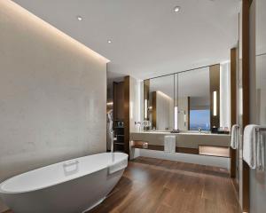 松江区にあるHyatt Regency Shanghai Songjiangのバスルーム(白いバスタブ、大きな鏡付)