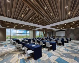 a conference room with tables and chairs and a screen at Hyatt Regency Shanghai Songjiang in Songjiang