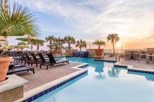 Hilton Vacation Club Oceanaire Virginia Beach في فرجينيا بيتش: مسبح مع كراسي الصالة والمحيط