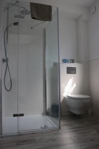 a bathroom with a glass shower and a toilet at Blu Bay in Grzybowo